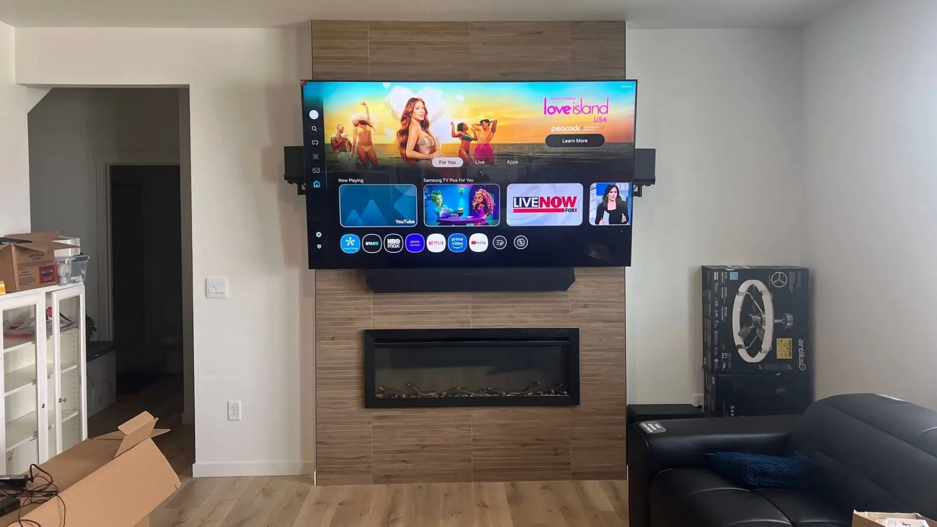TV and soundbar mounted on a wood-panel fireplace wall in a Colorado Springs living room